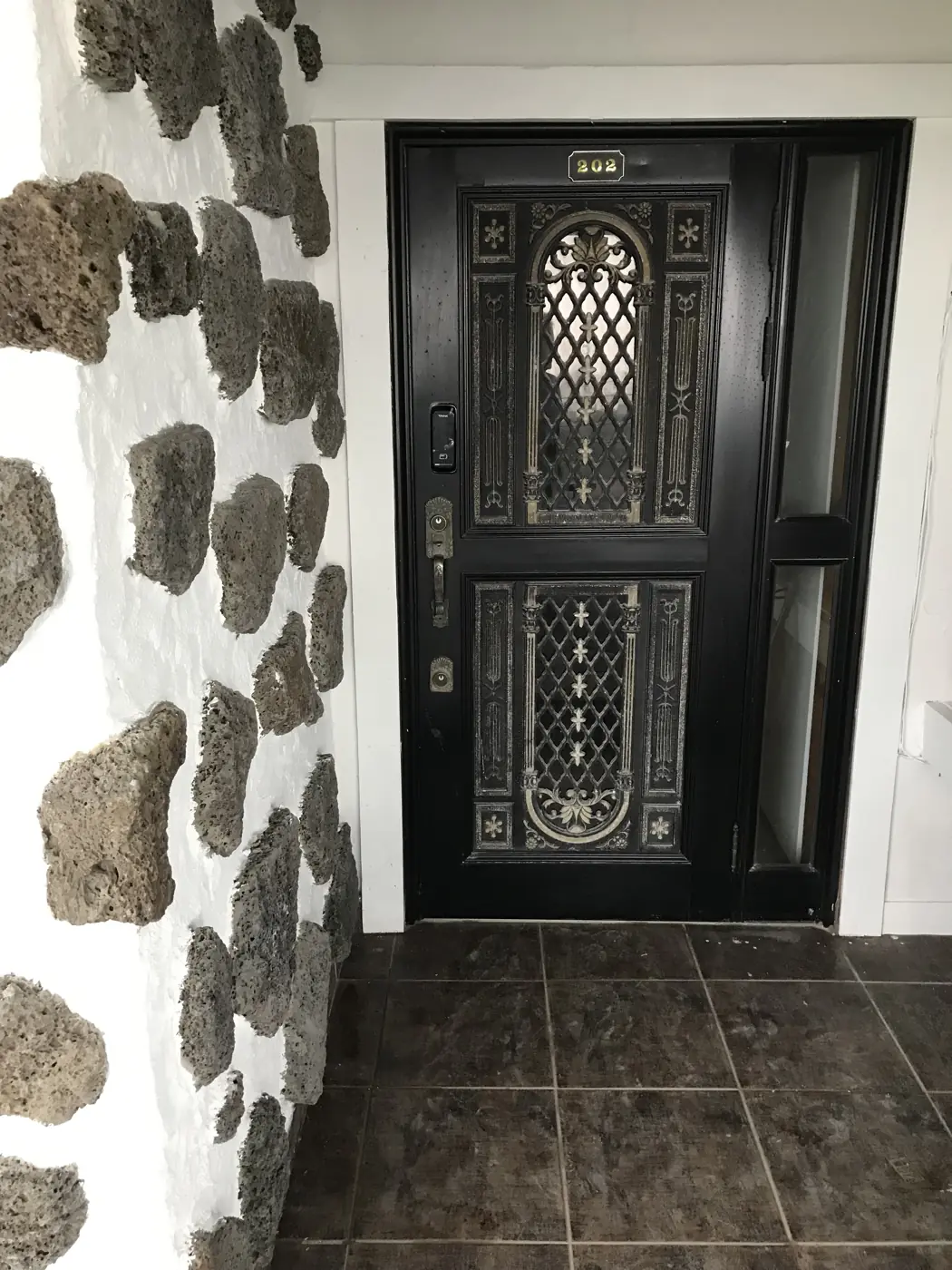 Cửa chính giữa tường đá basalt