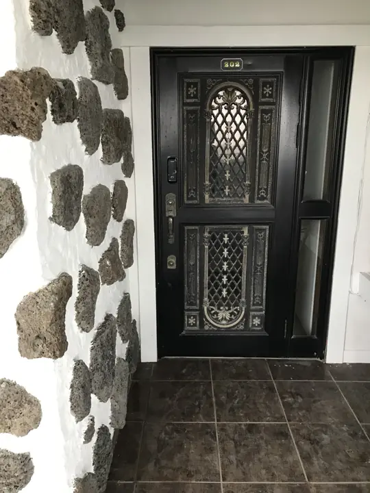 Cửa chính giữa tường đá basalt